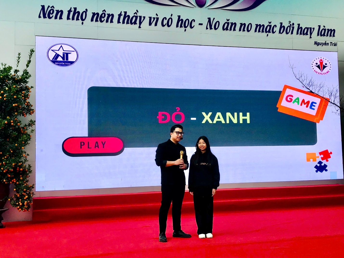 A person and person standing on a red carpet

Description automatically generated