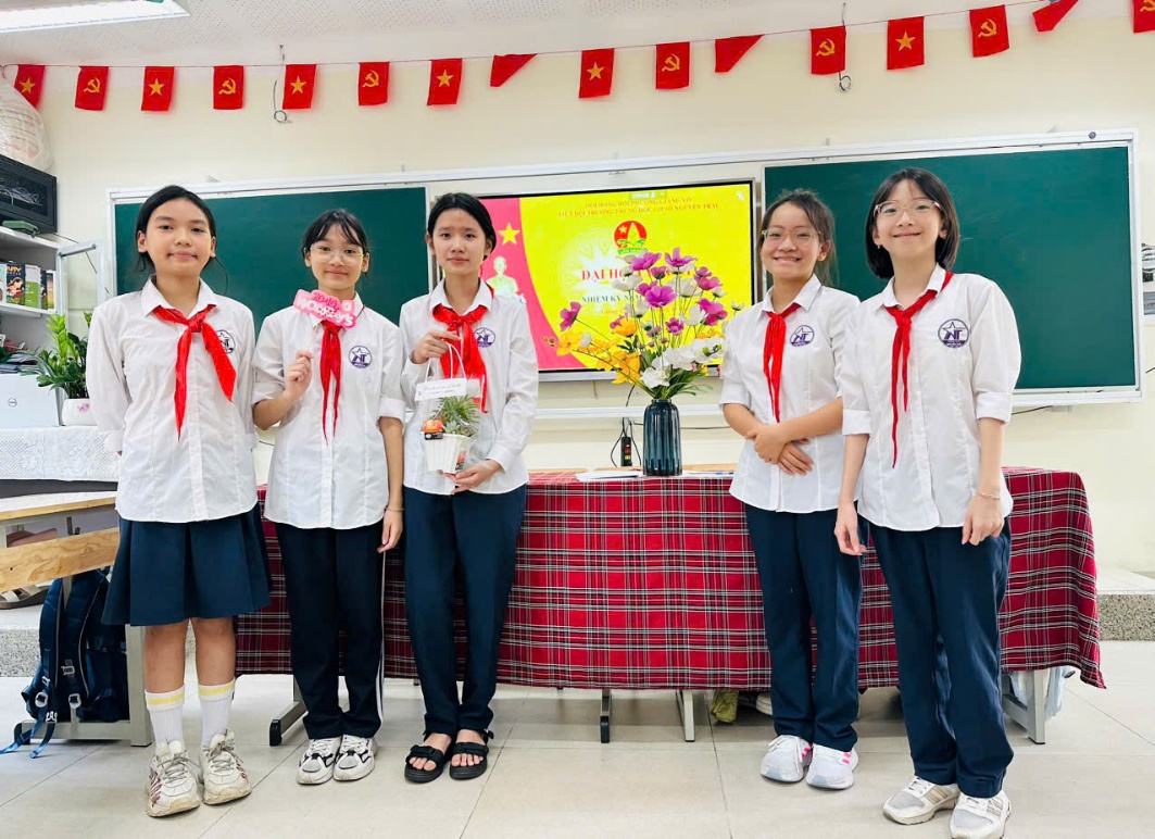 A group of girls in uniform standing in front of a table
AI-generated content may be incorrect.